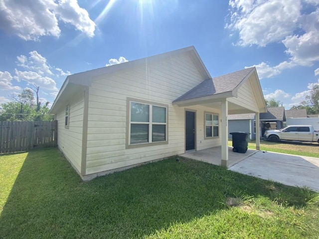 8046 Parker Rd, Houston, TX 77078 - view of side of home featuring fence, a patio area, driveway, and a yard