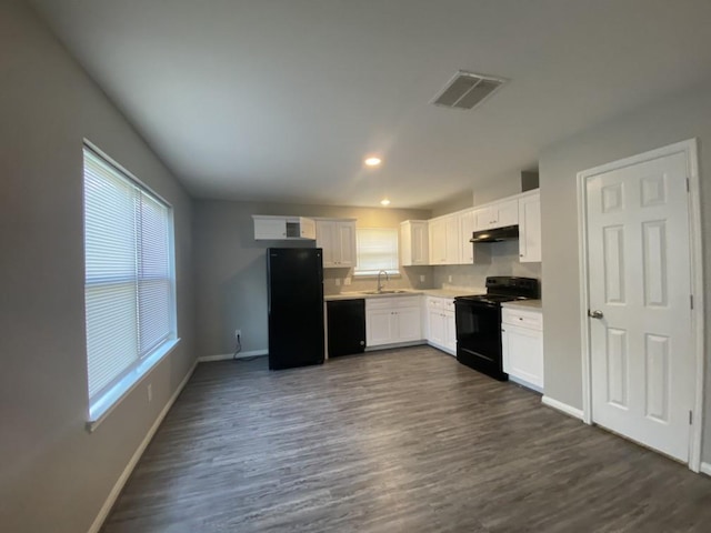 8046 Parker Rd, Houston, TX 77078 - kitchen featuring a sink, black appliances, baseboards, under cabinet range hood, and visible vents