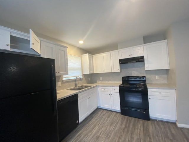8046 Parker Rd, Houston, TX 77078 - kitchen with under cabinet range hood, light countertops, wood finished floors, a sink, and black appliances