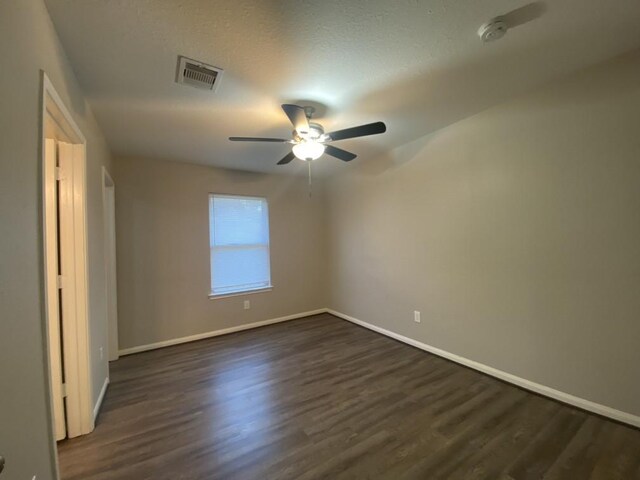 8046 Parker Rd, Houston, TX 77078 - unfurnished bedroom featuring baseboards, a ceiling fan, visible vents, and dark wood-type flooring