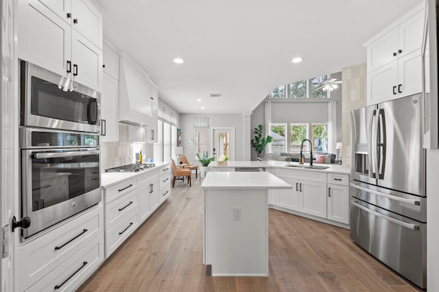 kitchen featuring stainless steel appliances, light countertops, recessed lighting, and a sink