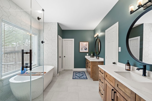 bathroom featuring two vanities, a tile shower, a soaking tub, and a sink