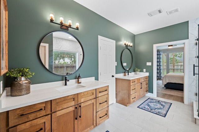 bathroom with visible vents, two vanities, and a sink