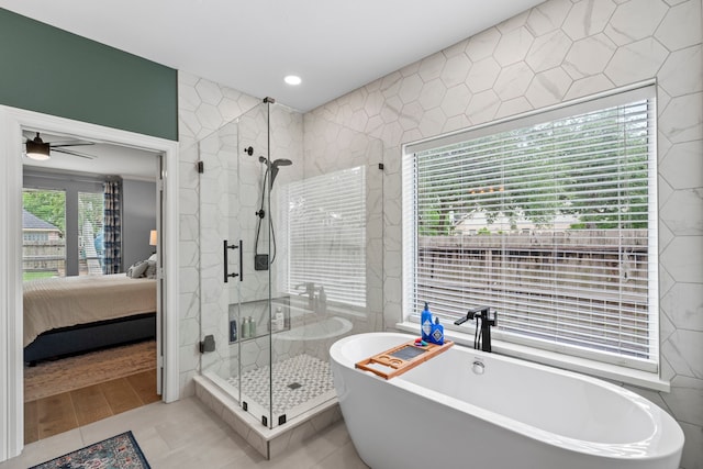 ensuite bathroom with ceiling fan, tile patterned floors, a stall shower, a soaking tub, and ensuite bathroom