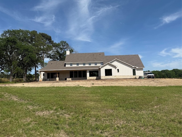 15420 Highlander Ct, Montgomery, TX 77356 - back of house with board and batten siding, a yard, and a chimney