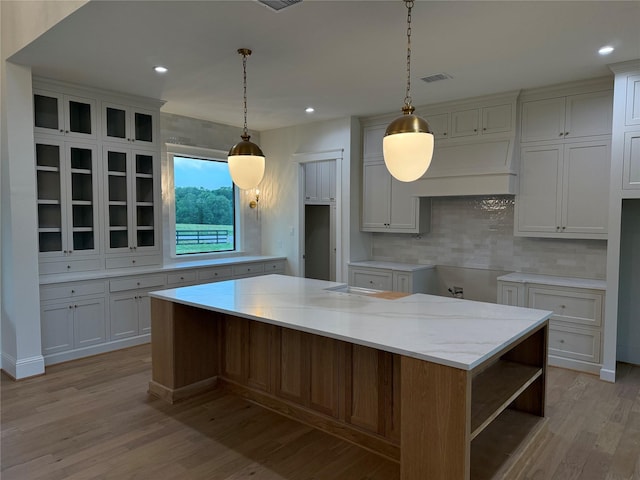 15420 Highlander Ct, Montgomery, TX 77356 - kitchen featuring light wood finished floors, decorative backsplash, a center island, white cabinets, and recessed lighting