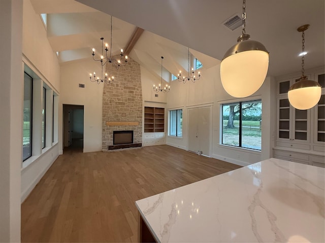 15420 Highlander Ct, Montgomery, TX 77356 - unfurnished living room with a chandelier, wood finished floors, high vaulted ceiling, beam ceiling, and a fireplace