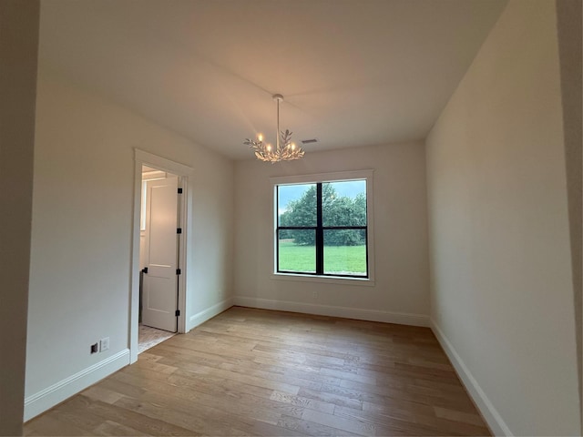 15420 Highlander Ct, Montgomery, TX 77356 - spare room featuring a chandelier, light wood-style flooring, and baseboards