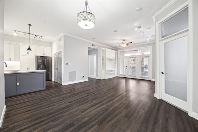 unfurnished living room with a ceiling fan, baseboards, rail lighting, and crown molding