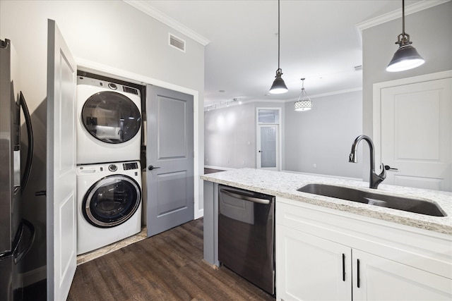 kitchen with a sink, stacked washing maching and dryer, stainless steel appliances, ornamental molding, and visible vents
