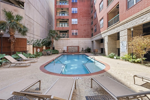community pool with fence and a patio area