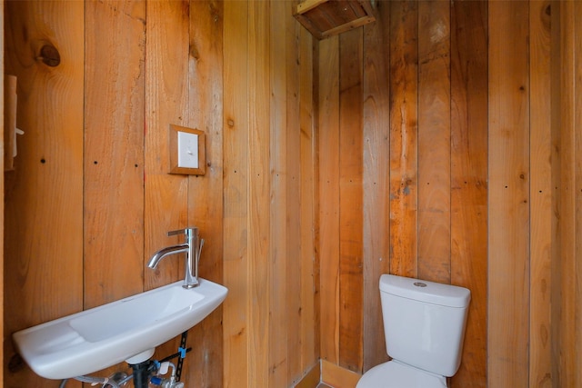 1319 E Brooklake Dr, Houston, TX 77077 - half bathroom with wood walls, a sink, and toilet