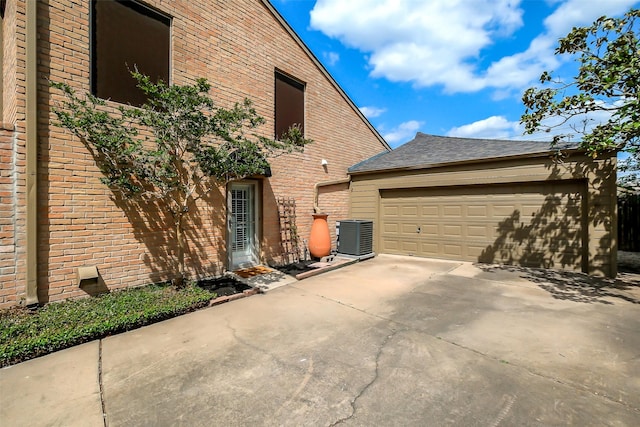 1319 E Brooklake Dr, Houston, TX 77077 - view of home's exterior featuring brick siding, driveway, central AC, and a garage