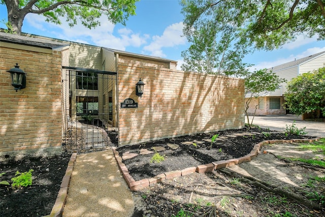1319 E Brooklake Dr, Houston, TX 77077 - view of property exterior featuring a gate and brick siding