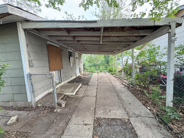view of parking featuring fence and a carport