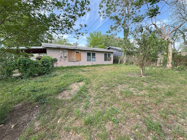 rear view of property with a yard and fence