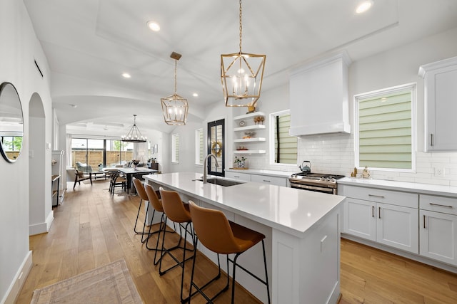805 Fisher St Unit B, Houston, TX 77018 - kitchen featuring a sink, stainless steel gas range oven, a chandelier, backsplash, and an island with sink