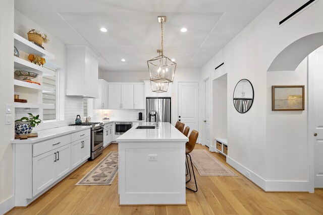 805 Fisher St Unit B, Houston, TX 77018 - kitchen with appliances with stainless steel finishes, tasteful backsplash, white cabinets, light countertops, and light wood-style floors