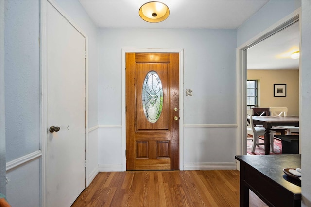 foyer entrance featuring wood finished floors, a wealth of natural light, and baseboards