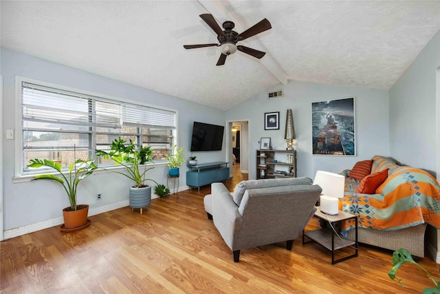 living area with lofted ceiling with beams, baseboards, visible vents, light wood-style floors, and a ceiling fan