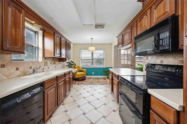 kitchen with black appliances, baseboards, a sink, and light countertops