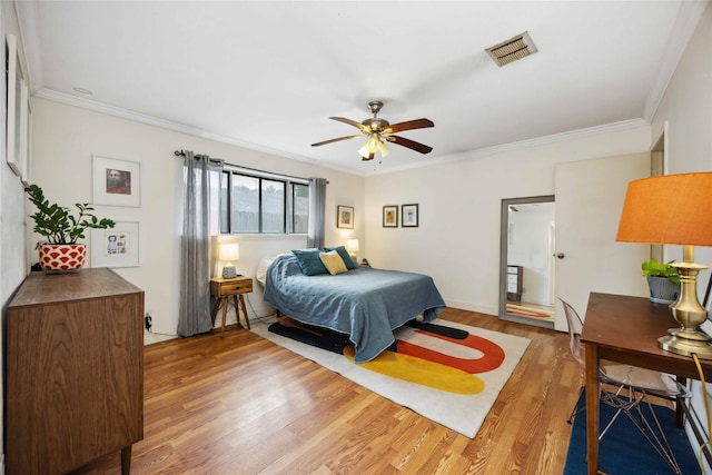 bedroom with ceiling fan, visible vents, crown molding, and light wood finished floors