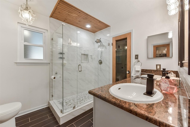full bathroom featuring baseboards, toilet, vanity, and a stall shower