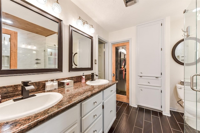 bathroom with baseboards, visible vents, a sink, and double vanity