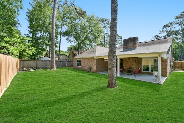 back of house featuring a patio area, a fenced backyard, brick siding, and a yard
