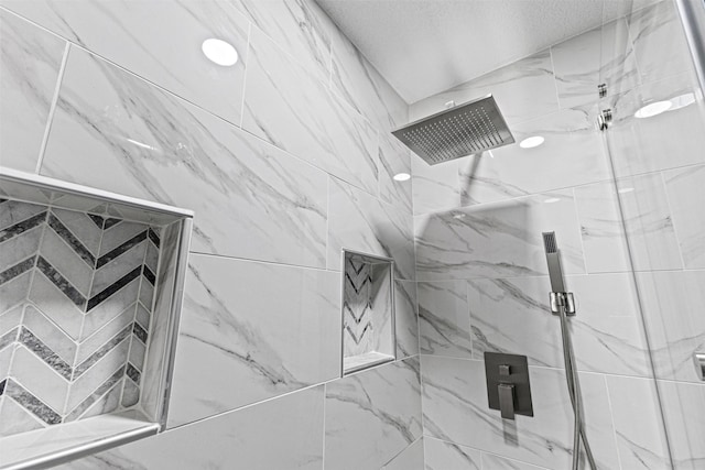 interior details with a textured ceiling and a marble finish shower