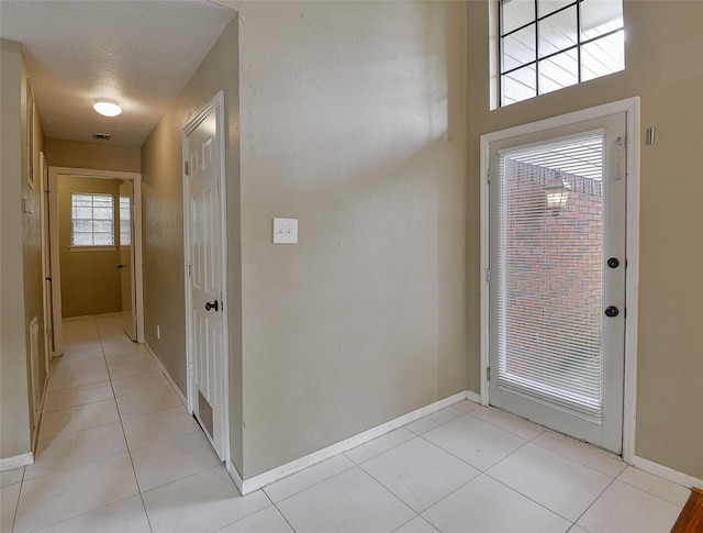 entrance foyer featuring baseboards and light tile patterned flooring