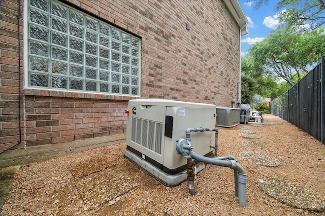 details with brick siding, a power unit, and fence