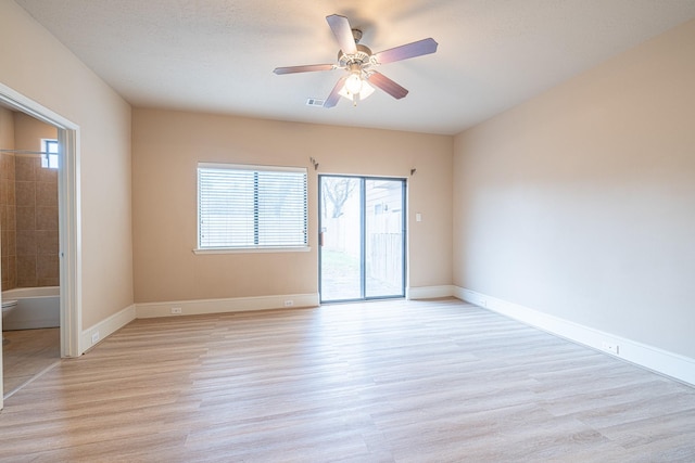 unfurnished room featuring light wood-style floors, visible vents, a ceiling fan, and baseboards