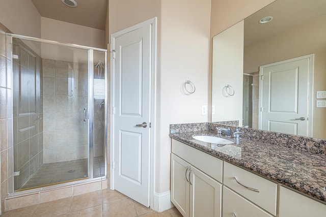 full bathroom with a shower stall, vanity, and tile patterned floors