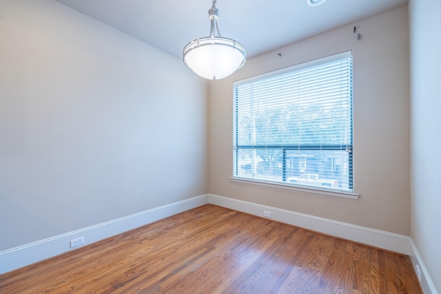 empty room featuring wood finished floors and baseboards
