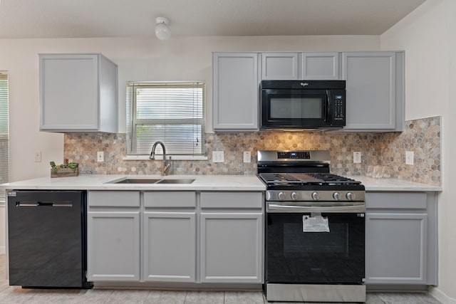kitchen with gray cabinets, black appliances, and a sink