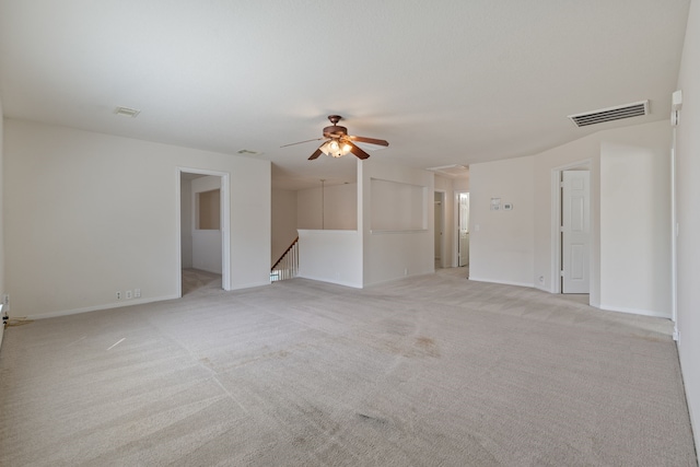 unfurnished living room featuring ceiling fan, baseboards, visible vents, and light colored carpet