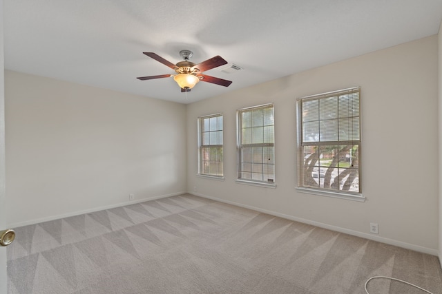unfurnished room with baseboards, visible vents, a ceiling fan, and light colored carpet