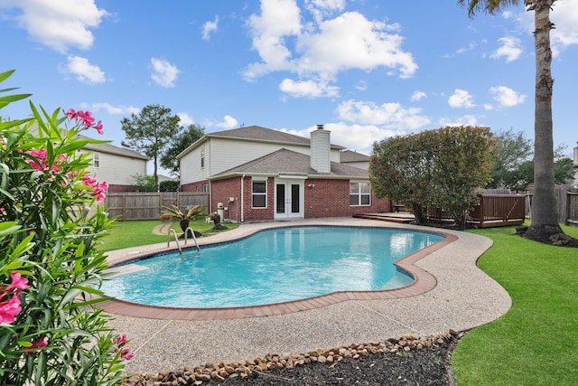 view of pool with a lawn, french doors, a fenced backyard, a patio, and a fenced in pool