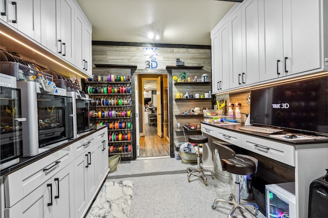 kitchen with open shelves, white cabinets, speckled floor, and dark stone counters
