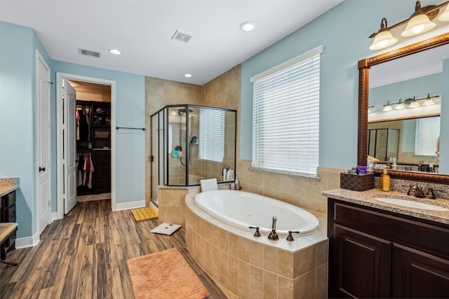 bathroom with a garden tub, vanity, visible vents, and a shower stall