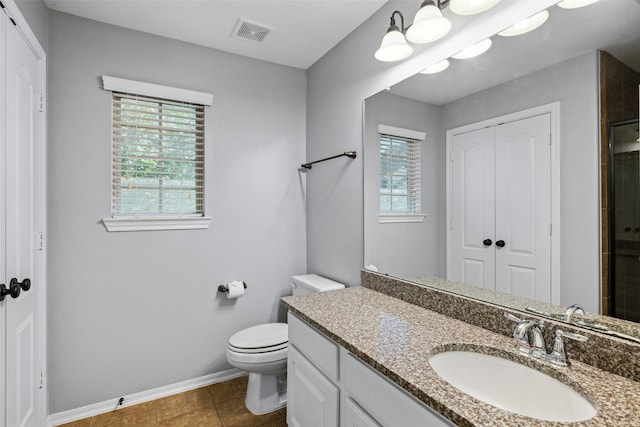 bathroom with plenty of natural light, vanity, toilet, and baseboards