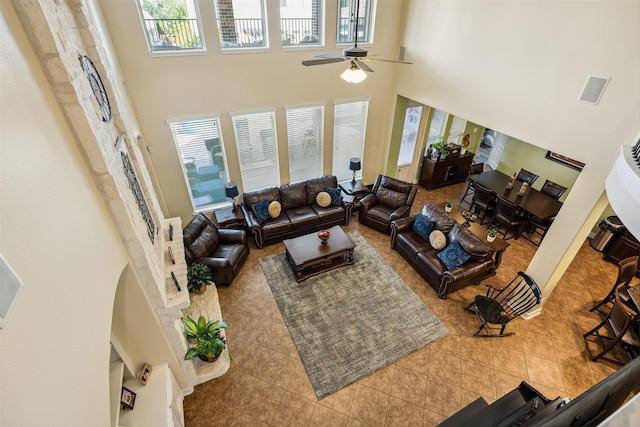 tiled living area with visible vents, a high ceiling, and ceiling fan