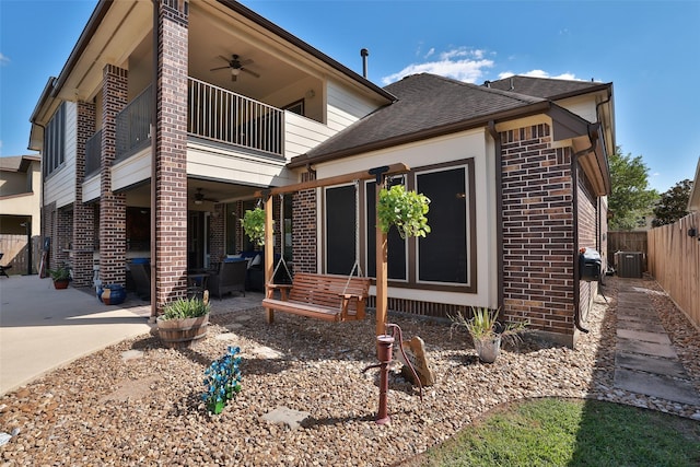 exterior space featuring brick siding, a ceiling fan, and a balcony