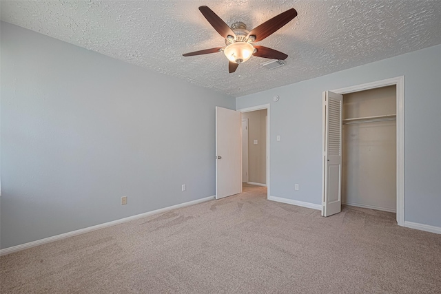 unfurnished bedroom featuring a textured ceiling, carpet, baseboards, a closet, and ceiling fan