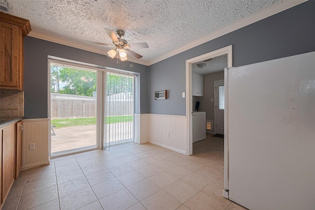 8326 Partlow Ln, Houston, TX 77040 - unfurnished dining area featuring a ceiling fan, wainscoting, a textured ceiling, light tile patterned floors, and crown molding