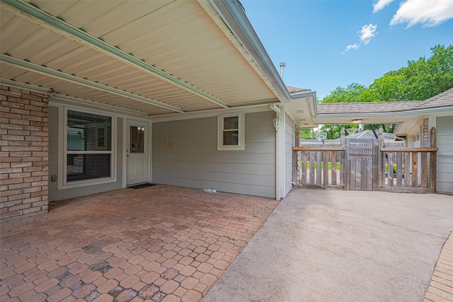view of patio featuring fence and a carport