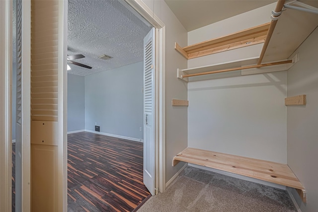 walk in closet with carpet floors and a ceiling fan