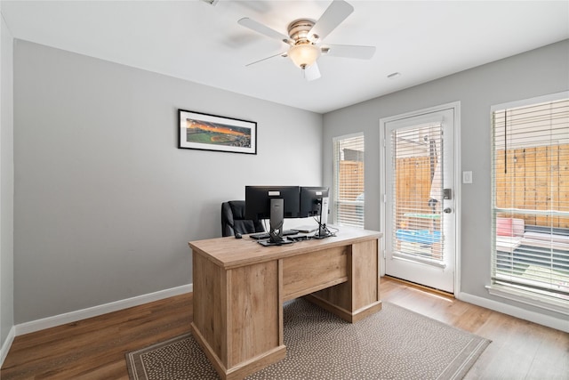 home office featuring a wealth of natural light, light wood finished floors, and baseboards