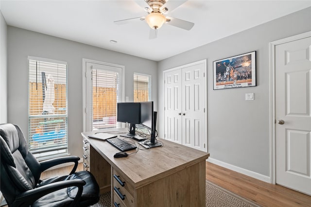 office space featuring light wood-type flooring, baseboards, and ceiling fan